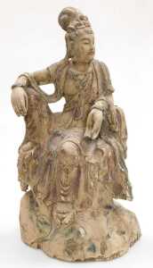 A Qing Dynasty 19thC Chinese wooden figure of Guanyin, modelled seated upon a rocky base,...