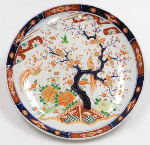 A Japanese Meiji period porcelain Imari charger, decorated with birds in a garden, with a prunus...
