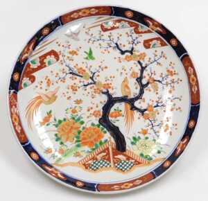 A Japanese Meiji period porcelain Imari charger, decorated with birds in a garden, with a prunus...