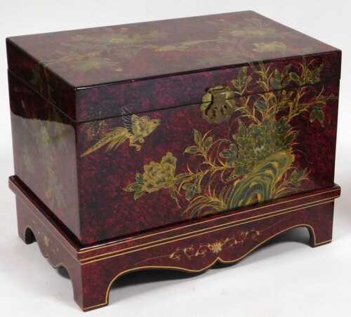 A Chinese scumbled red and black lacquer chest, decorated with birds and flowers, having a...