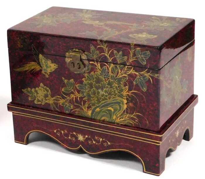 A Chinese scumbled red and black lacquer chest, decorated with birds and flowers, having a...