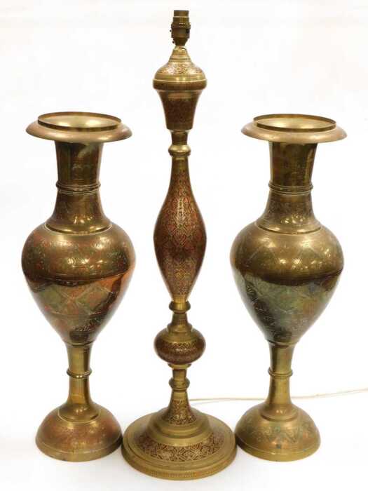 A 20thC Indian brass table lamp, highlighted in red and embossed with flowers, together with a...