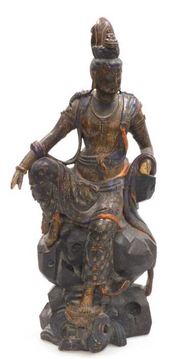 A Qing Dynasty late 19thC carved hardwood figure of Guanyin, modelled seated on a rocky base,...