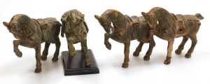 Four Chinese Tang style cast iron figures of war horses, one raised on a wooden plinth, with...