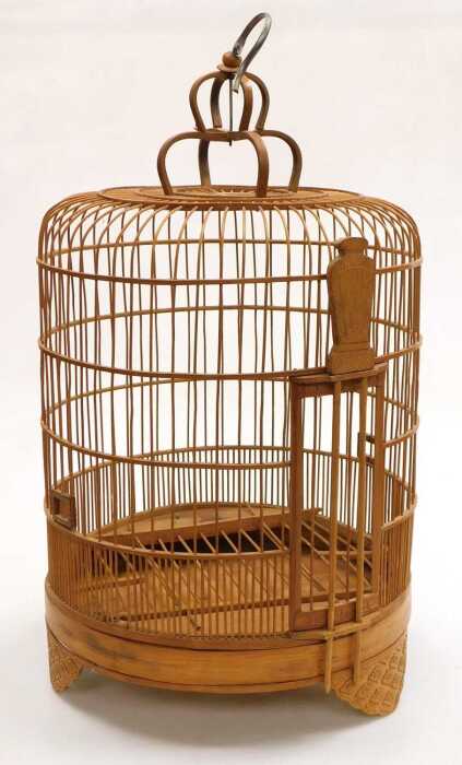 A Chinese bamboo bird cage, of cylindrical form, with a crown surmount, raised on three scroll...