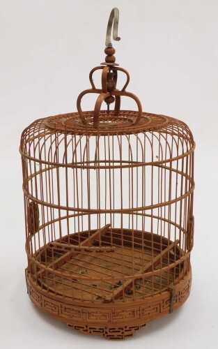 A Chinese bamboo bird cage, of cylindrical form, with a crown top, raised on three tapering...