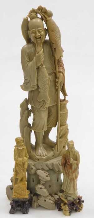 A 20thC Chinese soapstone figure of a fisherman, modelled standing on a rocky base, 40cm high,...