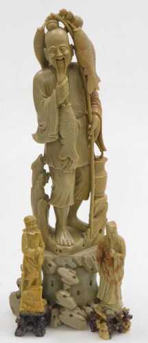 A 20thC Chinese soapstone figure of a fisherman, modelled standing on a rocky base, 40cm high,...
