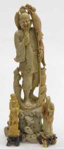 A 20thC Chinese soapstone figure of a fisherman, modelled standing on a rocky base, 40cm high,...