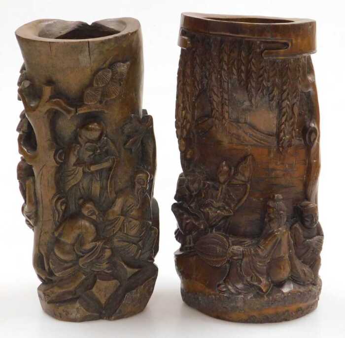 A 20thC Chinese carved bamboo brush pot, decorated in high relief with two figures seated upon...