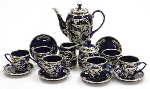 A Chinese cobalt blue pottery coffee service, with white metal overlay of dragons chasing...