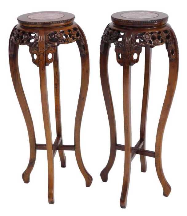 A pair of Chinese hardwood urn stands, the circular top inset with red marble, above a prunus...