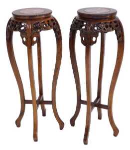 A pair of Chinese hardwood urn stands, the circular top inset with red marble, above a prunus...