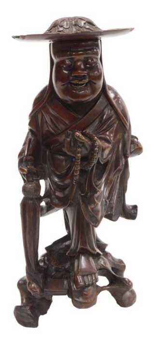 A late 19thC Chinese hardwood figure, modelled as a Buddhist monk, holding prayer beads and a...