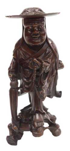 A late 19thC Chinese hardwood figure, modelled as a Buddhist monk, holding prayer beads and a...