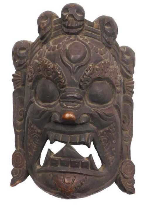 A Nepalese or Tibetan carved Mahakala mask, 32cm high, 24cm wide.