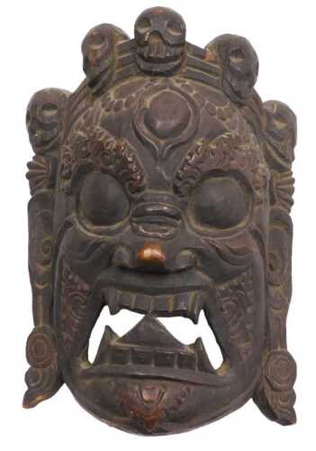 A Nepalese or Tibetan carved Mahakala mask, 32cm high, 24cm wide.