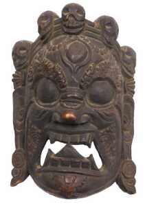A Nepalese or Tibetan carved Mahakala mask, 32cm high, 24cm wide.