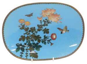 A Meiji period Japanese oval cloisonne dish, decorated with a bird, butterfly, and...