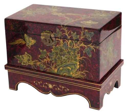 A Chinese red and black lacquer chest, decorated with birds and flowers, having a hinged lid...