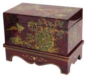 A Chinese red and black lacquer chest, decorated with birds and flowers, having a hinged lid...