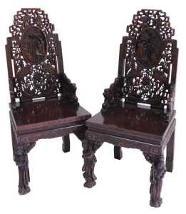A pair of early 20thC Chinese carved hardwood armchairs, with a fretwork back, having an oval...