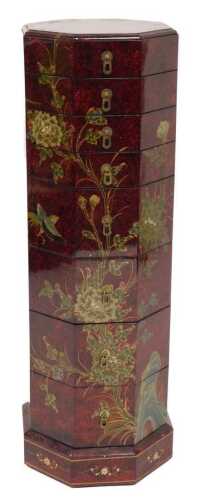 A Chinese red and black tiered box, of octagonal form, with eight graduated trays, decorated...