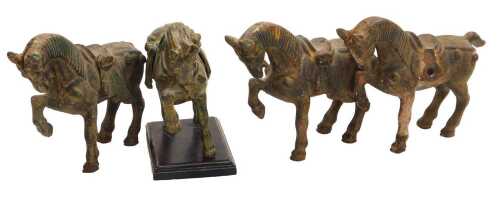 Four Chinese Tang style cast iron figures of war horses, one raised on a wooden plinth, with...