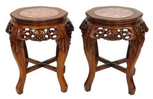 A pair of Chinese hardwood urn stands, the top inset with circular red marble, over fretwork...