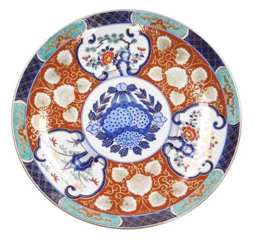 A late 20thC Japanese Imari charger, decorated with reserves of trees and prunus blossom, and...