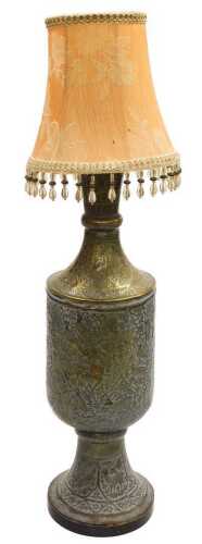 An early 20thC Anglo-Indian brass vase, converted to a table lamp, embossed with huntsman, gurus,...