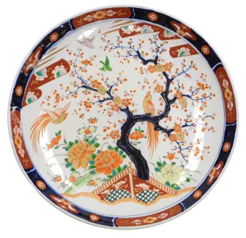 A Japanese Meiji period porcelain Imari charger, decorated with birds in a garden, with a prunus...