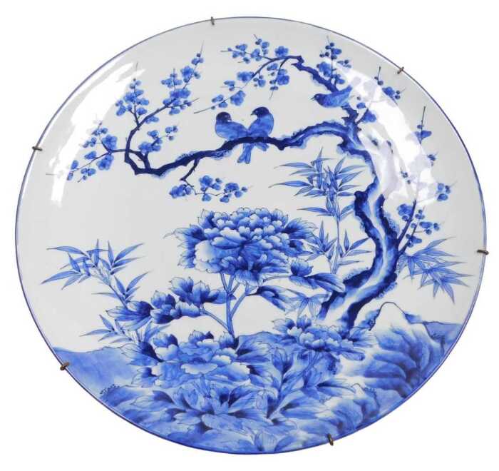 A Japanese Meiji period blue and white porcelain charger, decorated with birds, prunus blossom...