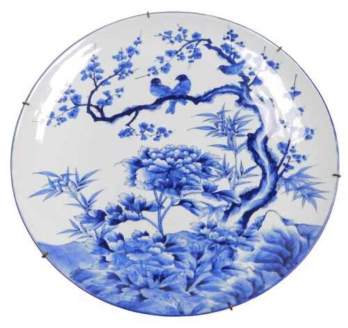 A Japanese Meiji period blue and white porcelain charger, decorated with birds, prunus blossom...