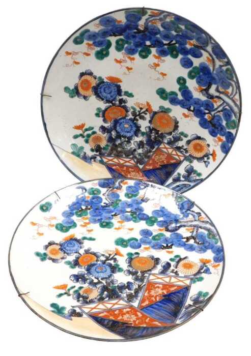 A pair of Japanese Meiji period Imari chargers, decorated with chrysanthemums and pine trees,...