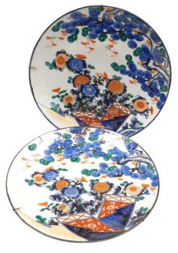 A pair of Japanese Meiji period Imari chargers, decorated with chrysanthemums and pine trees,...