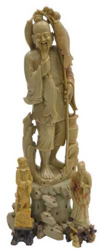 A 20thC Chinese soapstone figure of a fisherman, modelled standing on a rocky base, 40cm high,...