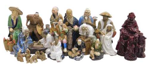A group of 20thC Chinese Shiwan mudman figures, including two men seated playing a board game,...