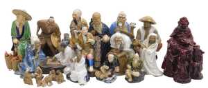 A group of 20thC Chinese Shiwan mudman figures, including two men seated playing a board game,...