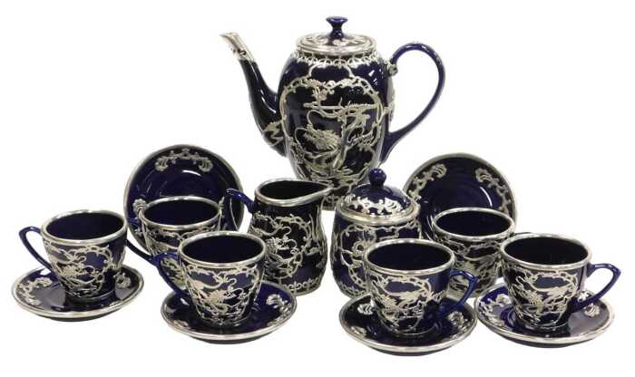 A Chinese cobalt blue pottery coffee service, with white metal overlay of dragons chasing...