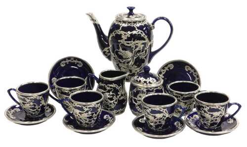 A Chinese cobalt blue pottery coffee service, with white metal overlay of dragons chasing...