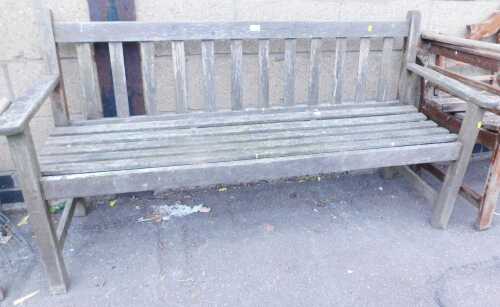 A teak garden bench, with a slatted seat and backrest, 145cm wide.