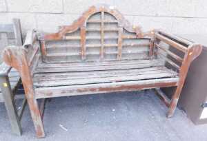 A teak garden bench, with a moulded arched back and slatted seat, 130cm wide, (AF), together...