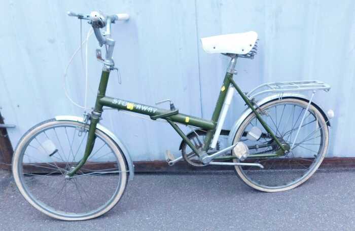 A Raleigh stowaway green folding bicycle, R-12, together with a Brooks sprung saddle.