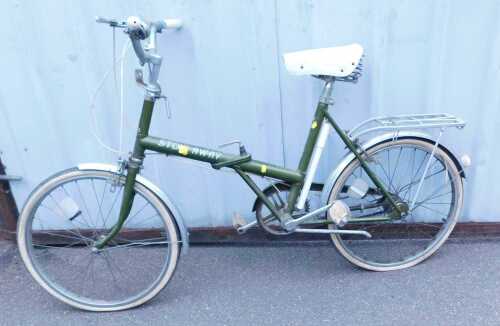 A Raleigh stowaway green folding bicycle, R-12, together with a Brooks sprung saddle.