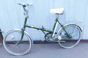 A Raleigh stowaway green folding bicycle, R-12, together with a Brooks sprung saddle.