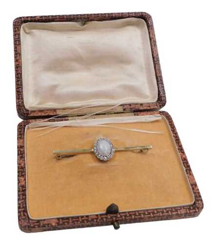 An opal and cz bar brooch, the cabochon opal in a surround of brilliant cut czs, in yellow metal,...