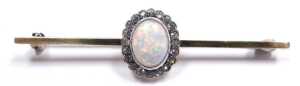 An opal and cz bar brooch, the cabochon opal in a surround of brilliant cut czs, in yellow metal,... - 2