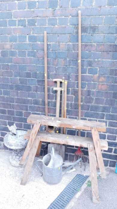 Two saw horses, together with a galvanised metal watering can, further garden tools, and a...