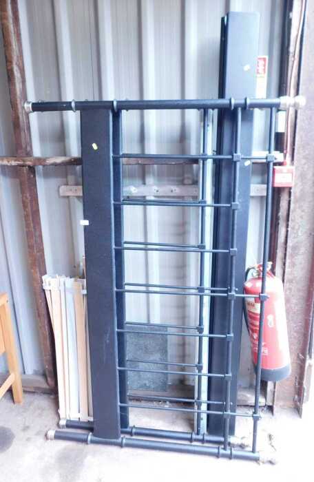 A black metal framed double bed, comprising headboard, footboard, side rails, and slats.